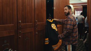 Adam Sandler as Happy Gilmore looking at a Bruins jersey in Happy Gilmore 2