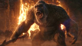 Kong stands roaring in front of lava, while holding an axe in Godzilla x Kong: The New Empire.