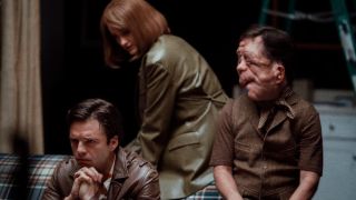 Sebastian Stan, Renate Reinsve, and Adam Pearson all dramatically sit on a couch together in A Different Man.